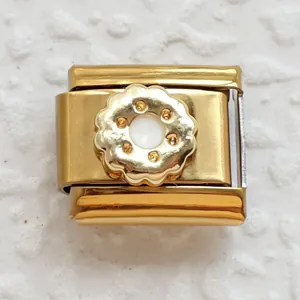 Macro shot of a golden stainless steel modular charm link with orange crystals
