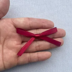 Nahaufnahme einer handgefertigten burgunderroten Satinschleife für DIY-Kleidung