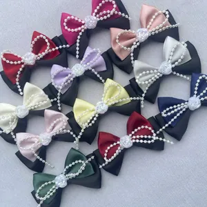 Detalle de lazos de satén hechos a mano con cadenas de perlas en varios colores para bricolaje