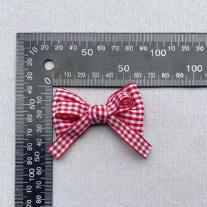 Detailed close-up of a 4.5cm red gingham plaid bow for DIY crafts with a ruler scale