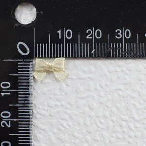Macro detail of 8mm cream satin ribbon bow for DIY doll clothes with ruler measurement