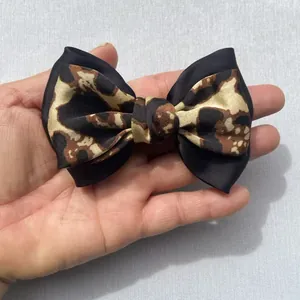 Detalle de un lazo para el pelo hecho a mano con estampado de leopardo y satén negro