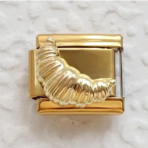 Macro view of a golden croissant-shaped Italian charm link made of polished stainless steel