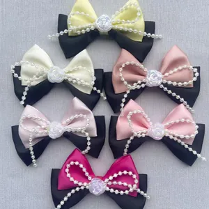 Detalle de lazos para el pelo hechos a mano con perlas y rosas en seis colores elegantes