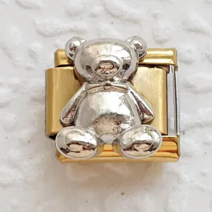Macro detail of bicolored bear charm link with silver relief and golden base for DIY bracelet