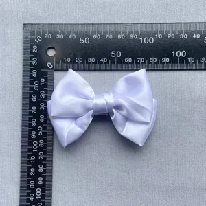 Close-up of white satin bow showing 80mm width measurement for DIY apparel decoration