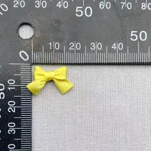 Vista dall'alto di un piccolo fiocco di raso giallo fatto a mano con righello graduato
