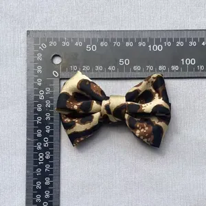 Detalle de un lazo de raso de 80 mm con estampado de leopardo y regla de medida
