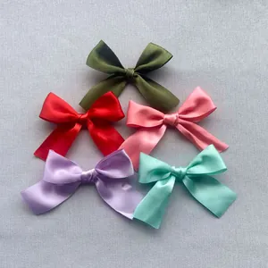 Flat lay of colorful 7.5cm satin ribbon bows in olive, red, pink, purple, and mint green