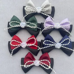 Detalle de lazos de satén multicolor para el pelo con perlas y decoraciones florales