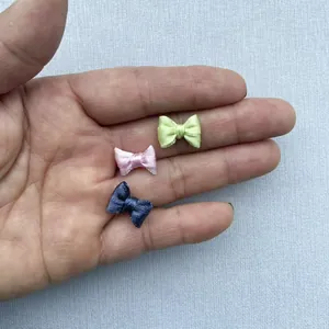 Primer plano de mini lazos de cinta de raso hechos a mano de 1,5cm para ropa de muñecas DIY