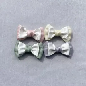 Detailed macro view of four colorful satin and organza DIY multi-layer bow accessories