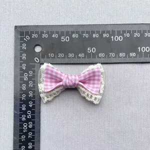 Detailed view of pink plaid bow accessory with white lace trim and 45mm measurement