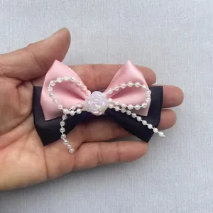 Lazo de satén rosa y negro hecho a mano con cuentas y detalle de rosa de resina blanca