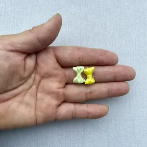 Vista macro de mini lazos de satén de 1,5 cm hechos a mano en verde y amarillo