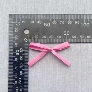 Nahaufnahme einer rosa Bandschleife mit 45 mm Breitenmessung auf dem Lineal