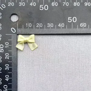 Dettaglio di un fiocco di raso giallo pallido da 20 mm misurato con riga per il fai da te