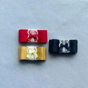 Gedetailleerd beeld van handgemaakte satijnen en kanten strikken in rood, goud en zwart