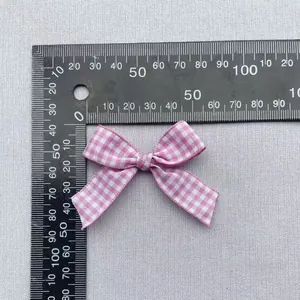 Pink gingham bow accessory for DIY crafts with 4.5cm width and 3.5cm height dimensions