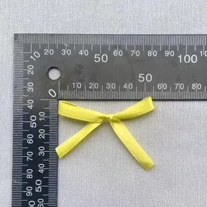 Makro-Detail einer 45mm gelben Satin-Schleife mit Messwerkzeug für Skala und Größe