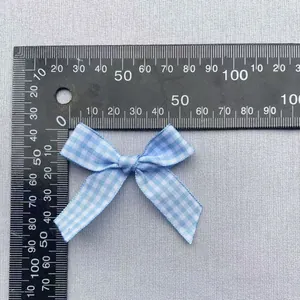 Detailed measurement of blue plaid ribbon bow accessory showing 45mm width on a ruler