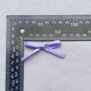 Makro-Detail einer 40 mm lila Satin-Schleife für DIY-Bekleidungszubehör