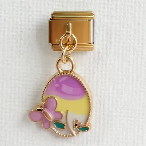 Makroaufnahme von italienischem Gold-Charm mit lila Schmetterling und Emaille-Blättern