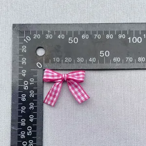 Detailed view of small pink gingham bow with measuring ruler for DIY clothing accessories