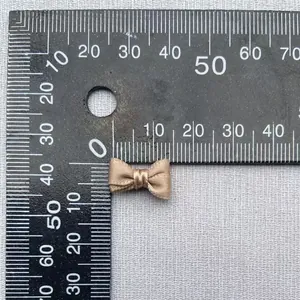 Vista detallada del tamaño del mini lazo de satén beige de 1,5 cm para ropa de muñecas