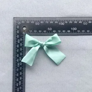 7.5cm mint green satin bow accessory measured with a ruler for hair and clothing crafts