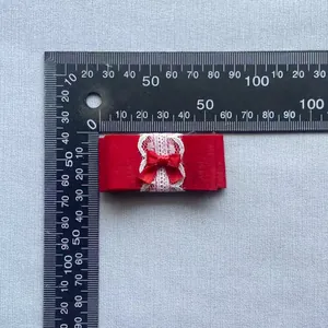 Rode Lolita dubbele kanten strik accessoire met meetschaal toont 7cm lengte aan