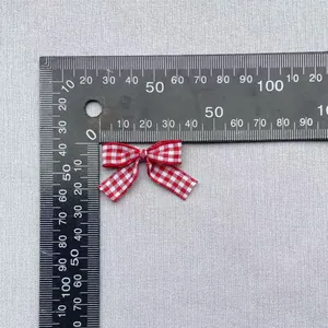 Detailed view of red gingham fabric bow with a ruler showing the 25mm size specifications
