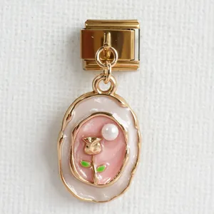 Makroaufnahme von italienischem Gold-Charm mit Emaille, Rosendekor und Perle