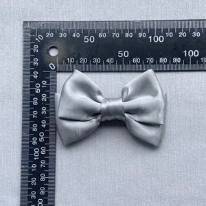 Detail view of silver grey satin double bow accessory with measurement scale reference