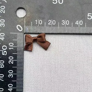 Dettaglio fiocco in raso marrone caffè largo 1,5 cm con scala graduata di precisione