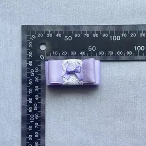 Detailopname van een paarse gelaagde kanten strik met een liniaal voor DIY-handwerkmaten