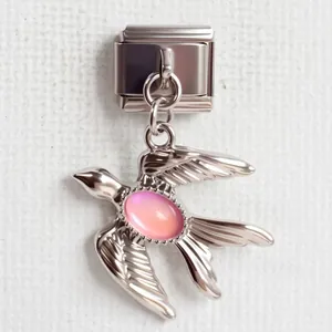 Makroaufnahme eines italienischen Edelstahl-Charms mit silberner Schwalbe und rosa Stein