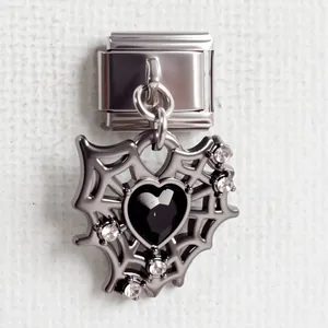 Makroaufnahme vom silbernen Italian Charm mit Spinnennetz und schwarzem Herzstein