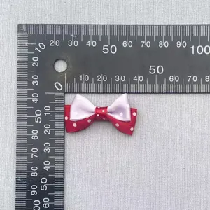 Close-up of a 35mm double-layer polka dot bow with purple and red satin for DIY crafts