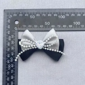 Detalle de un lazo de satén hecho a mano con rosa blanca y perlas para decoración DIY
