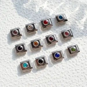 Macro shot of 12 colorful birthstones set in silver stainless steel Italian charms