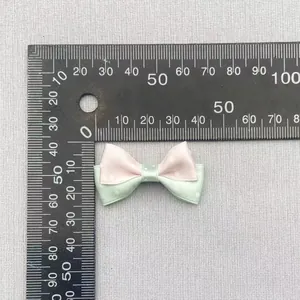 Detail showing 4cm pink and green polka dot bow measurements on a metric ruler