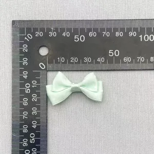Detail view of a 4cm mint green double-layer polka dot bow with ruler measurements