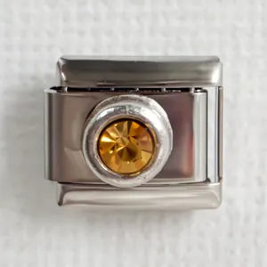 Macro shot of stainless steel Italian charm link with an amber gemstone for DIY bracelets