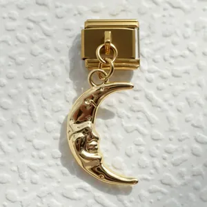 Macro de un charm italiano de acero dorado con colgante vintage de cara de luna esculpida
