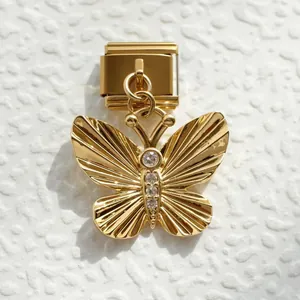 Detalle de dije de mariposa dorada con cristales en pulsera de eslabones italianos