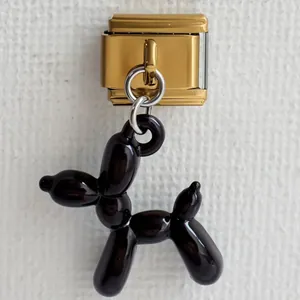 Dettaglio del ciondolo a forma di cane palloncino nero su maglia componibile dorata