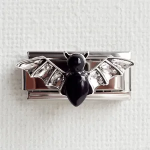 Détail macro d'un charm de chauve-souris gothique en émail noir et métal argenté texturé