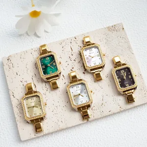 Dettaglio di orologi al quarzo quadrati da donna con ghiere in strass e cinturini dorati