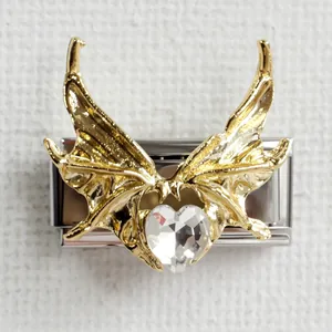 Detail of Italian charm link featuring gold wings and heart-shaped crystal on steel
